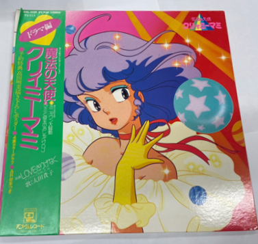 『魔法の天使クリィミーマミ』のドラマ編LPレコード。マミのイラストが描かれたカラフルなジャケットに、緑色の帯が付属している。