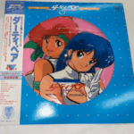 アニメ『ダーティペア』のピクチャーレコード。主人公のケイとユリが描かれた盤面と、水玉模様の青いパッケージが特徴。