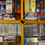 アニメや特撮関連のDVDボックスや単品ソフトが複数詰められた黄色いカゴ。90年代〜2000年代作品を中心とした大量買取品。